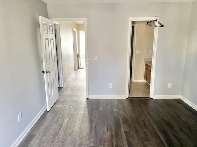 unfurnished bedroom featuring dark wood finished floors and baseboards