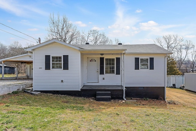 bungalow-style house with a porch, fence, crawl space, a carport, and a front lawn