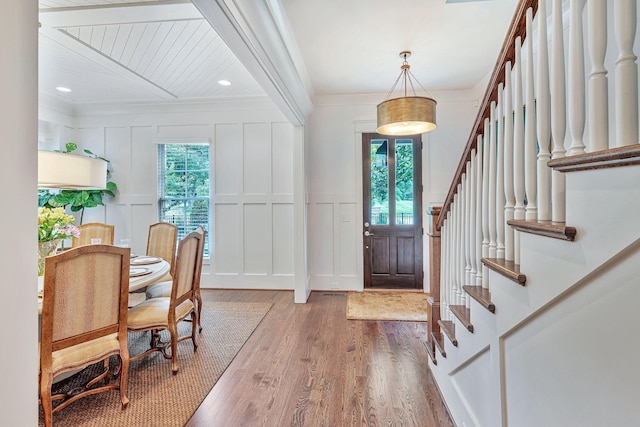 foyer with ornamental molding, plenty of natural light, and a decorative wall