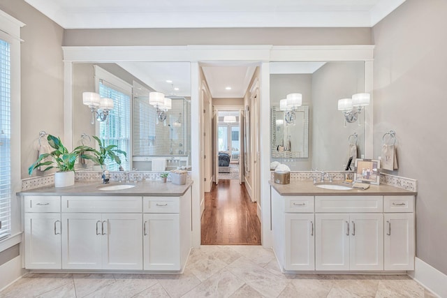 full bath featuring a shower stall, two vanities, and a sink