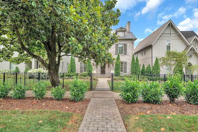 view of front of home with a chimney, a standing seam roof, a gate, metal roof, and fence