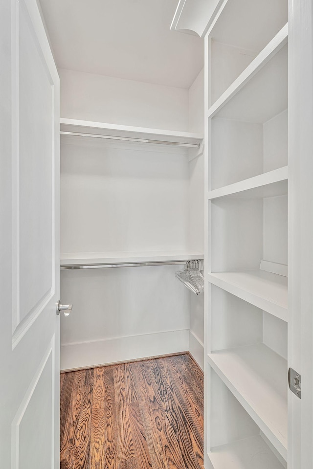 walk in closet with wood finished floors