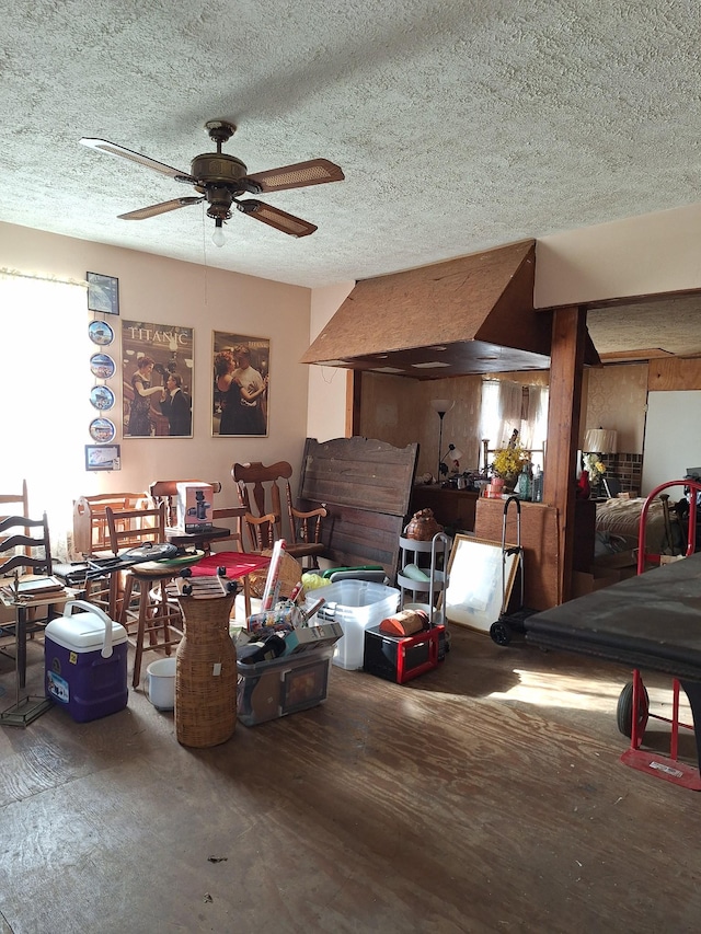 misc room with a ceiling fan, a textured ceiling, and wood finished floors