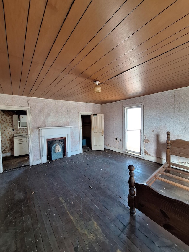 unfurnished living room with dark wood finished floors, wooden ceiling, and a fireplace