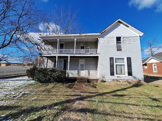 rear view of house featuring a yard and a balcony