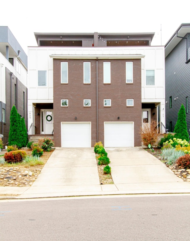 view of front facade with a garage, driveway, and brick siding