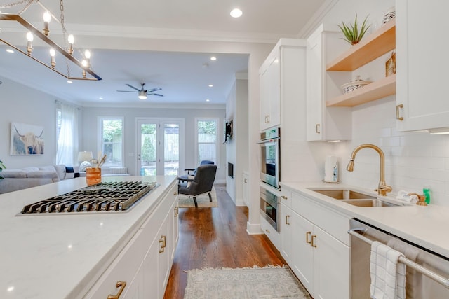 kitchen featuring light stone counters, dark wood-type flooring, a sink, white cabinetry, and appliances with stainless steel finishes