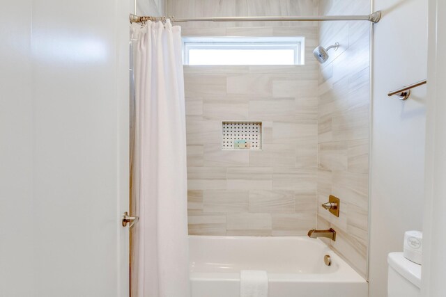 bathroom featuring shower / bath combination with curtain and toilet