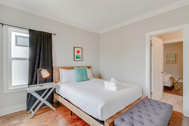 bedroom featuring crown molding, baseboards, and wood finished floors