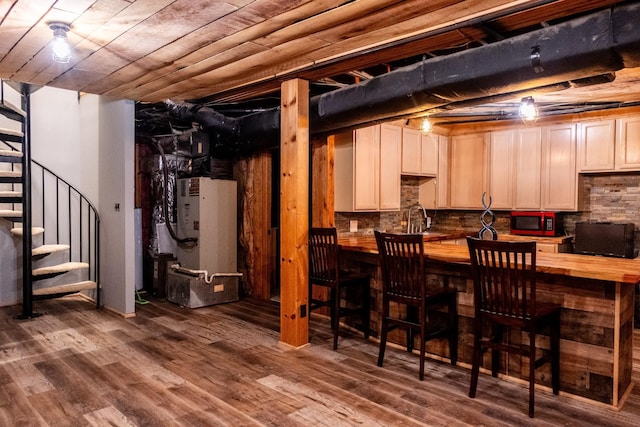 finished below grade area with a sink, wood ceiling, stairs, heating unit, and dark wood-style floors