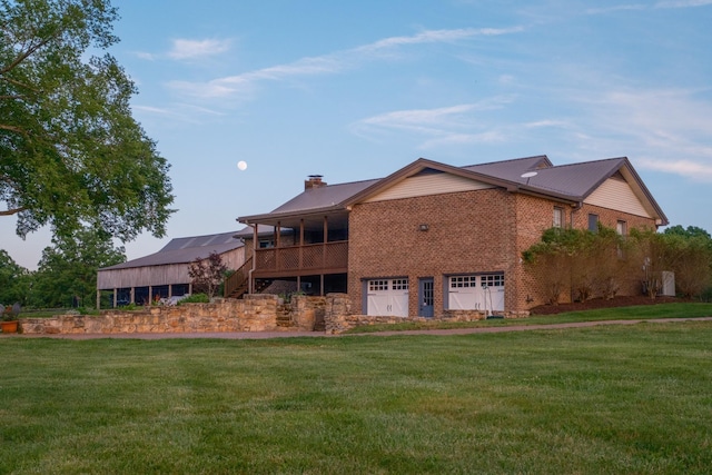 view of front of home featuring a garage, brick siding, a chimney, and a front yard