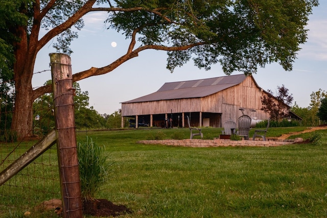 exterior space with a barn, a detached garage, and an outbuilding