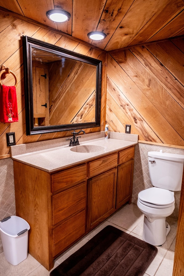 half bathroom featuring wooden walls, toilet, wood ceiling, tile patterned floors, and vanity