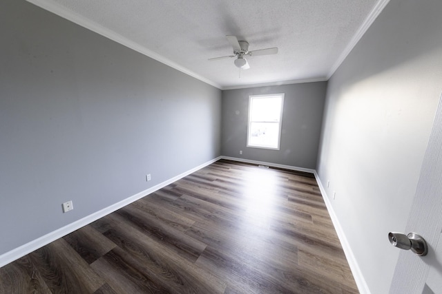 spare room with baseboards, a textured ceiling, ornamental molding, and dark wood-type flooring