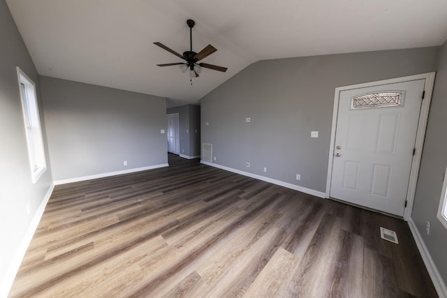 unfurnished living room featuring dark wood finished floors, visible vents, vaulted ceiling, and baseboards