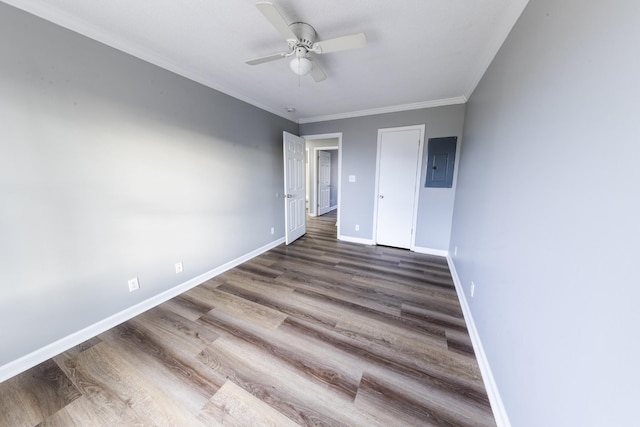 unfurnished bedroom featuring electric panel, baseboards, dark wood finished floors, a ceiling fan, and ornamental molding