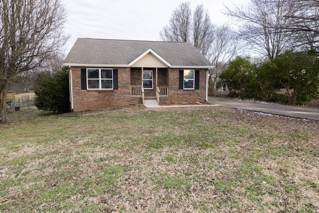 single story home with brick siding, roof with shingles, and a front yard