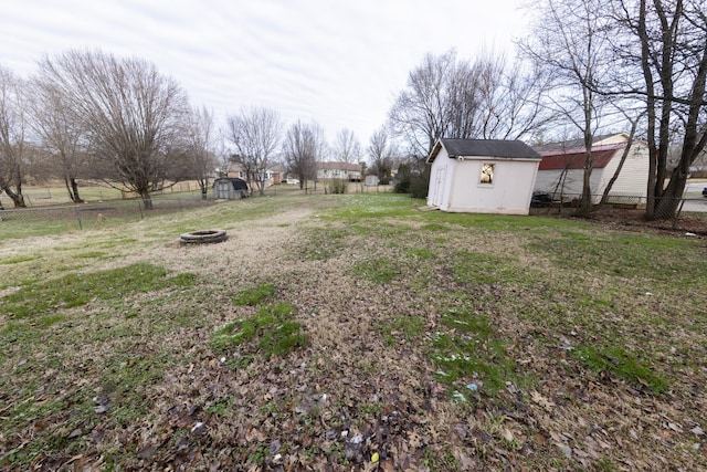 view of yard with a storage unit, an outdoor fire pit, and an outdoor structure