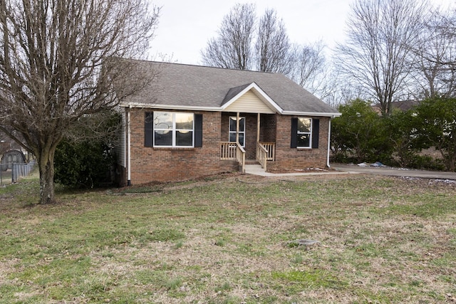 ranch-style house featuring brick siding, a front lawn, and roof with shingles