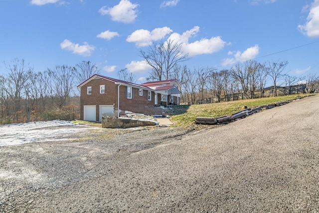 view of front facade with an attached garage, driveway, and brick siding