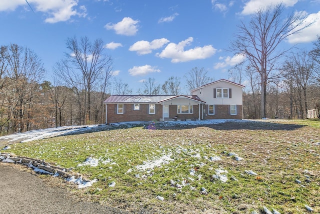 view of front of house with brick siding and a front yard