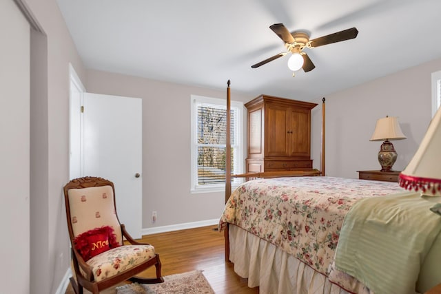 bedroom with a ceiling fan, light wood-style flooring, and baseboards