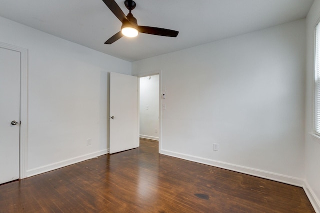 unfurnished bedroom with a ceiling fan, baseboards, and dark wood-type flooring