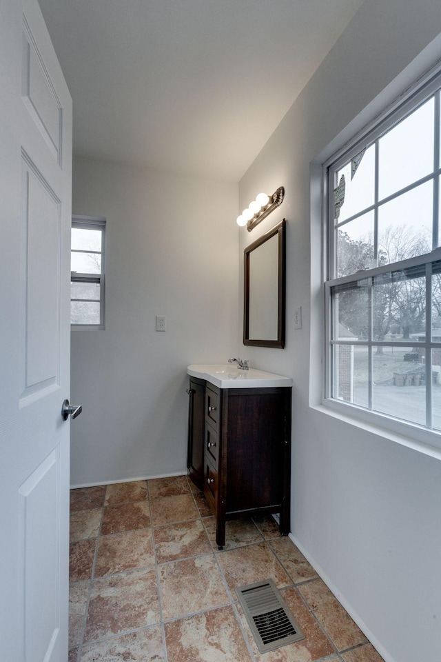 bathroom featuring stone finish floor, visible vents, and vanity