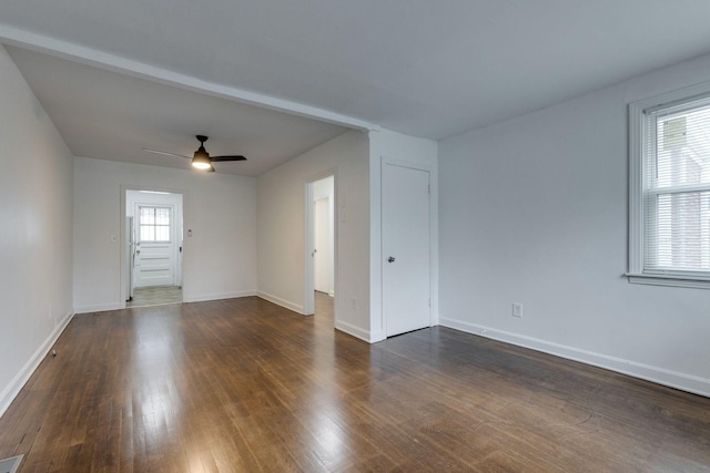 spare room featuring dark wood-type flooring, ceiling fan, and baseboards