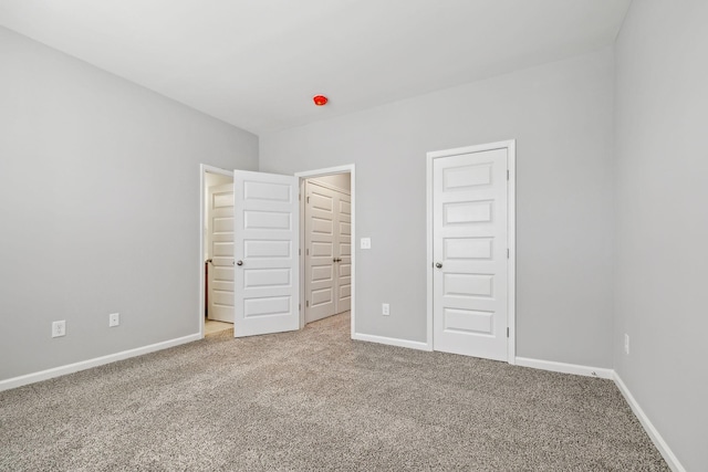 unfurnished bedroom featuring carpet floors and baseboards