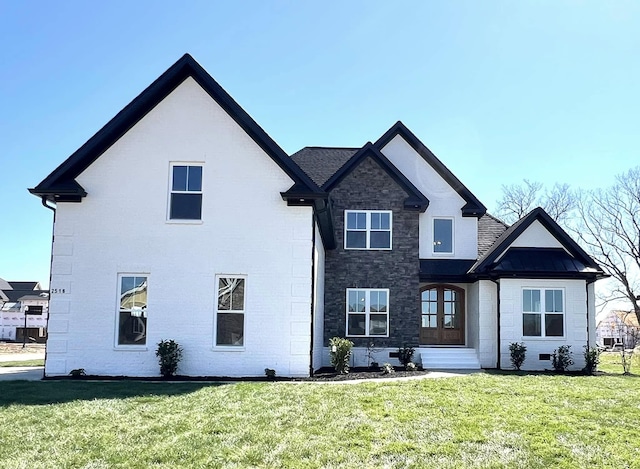 rear view of property featuring stone siding and a lawn