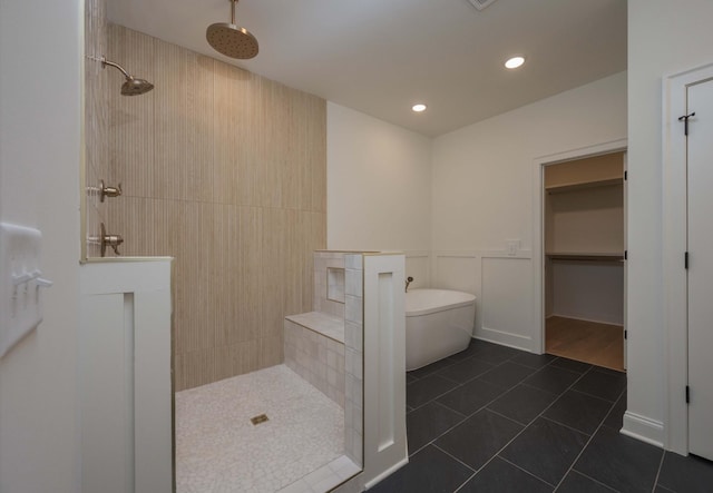 bathroom with a freestanding tub, a decorative wall, walk in shower, and tile patterned floors