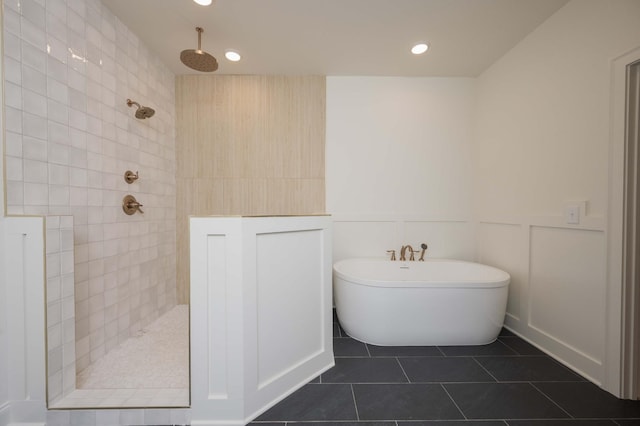 full bathroom featuring a walk in shower, a decorative wall, a wainscoted wall, a soaking tub, and tile patterned floors