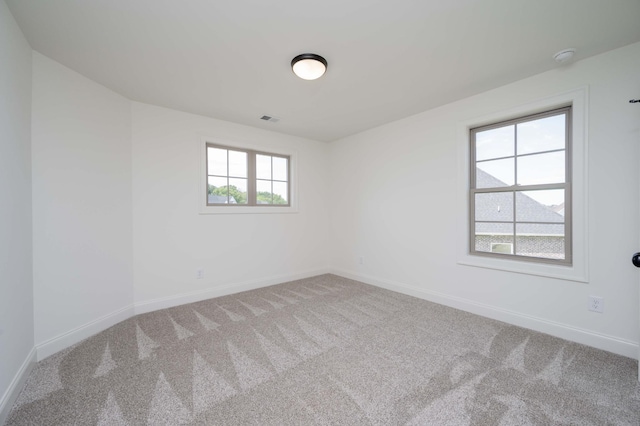 carpeted empty room featuring visible vents and baseboards