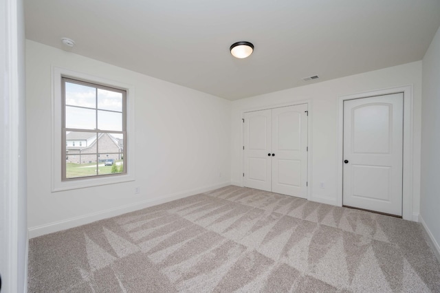 unfurnished bedroom featuring carpet floors, visible vents, and baseboards