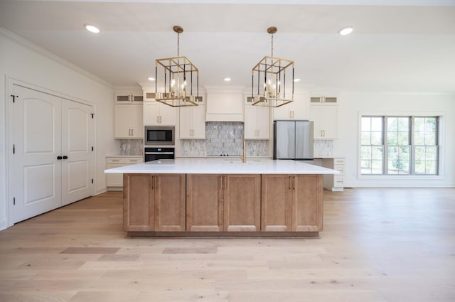 kitchen with a large island, appliances with stainless steel finishes, glass insert cabinets, and white cabinets