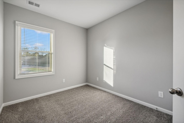 carpeted empty room with visible vents and baseboards