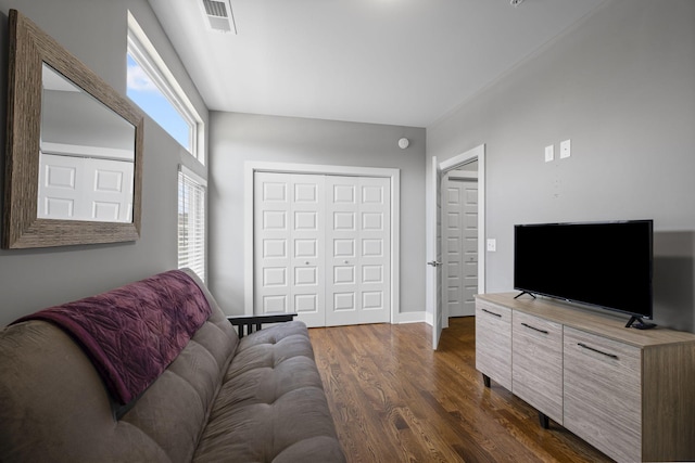 living area with baseboards, visible vents, and dark wood-style flooring