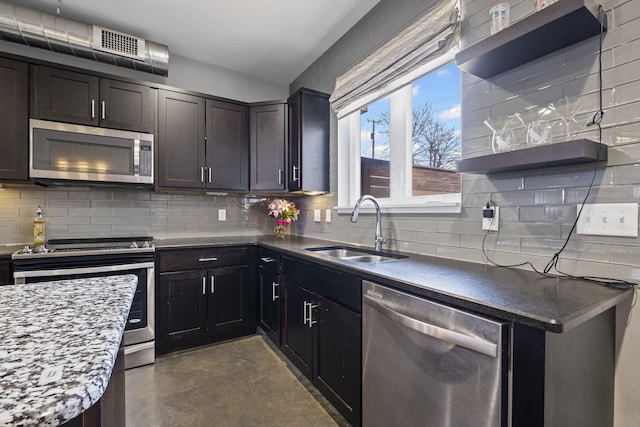 kitchen with open shelves, stainless steel appliances, tasteful backsplash, a sink, and concrete flooring