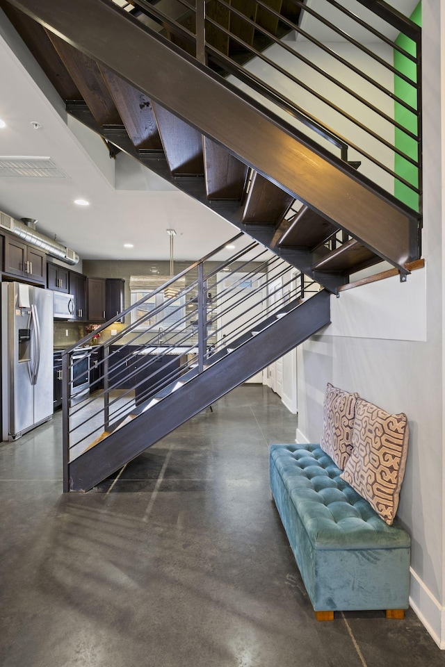 stairway featuring visible vents, concrete floors, baseboards, and recessed lighting