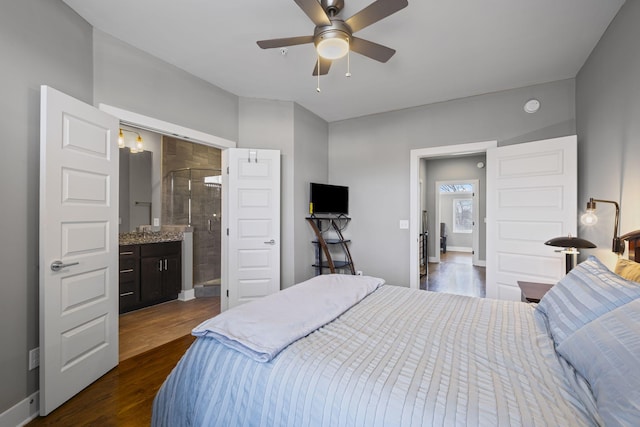 bedroom with ceiling fan, dark wood-type flooring, connected bathroom, and baseboards