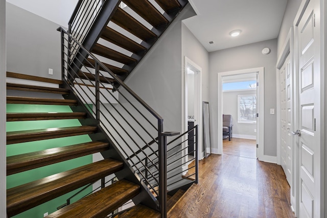 stairs featuring visible vents, baseboards, and wood finished floors