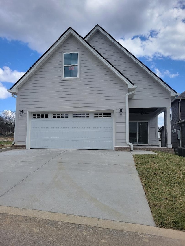 view of front of house featuring a garage, driveway, and a front lawn