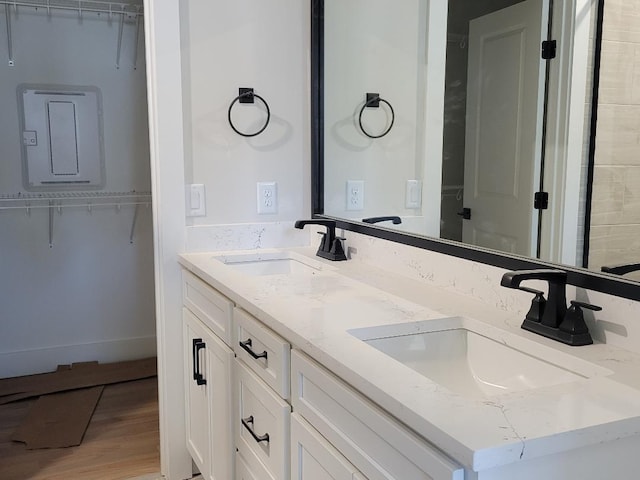 bathroom featuring double vanity, a sink, and wood finished floors