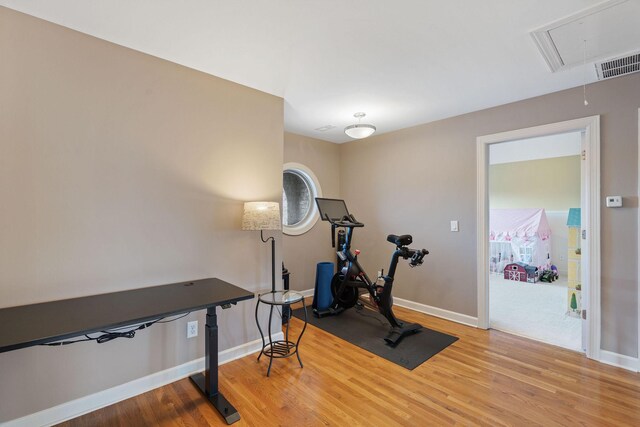 workout area with visible vents, wood finished floors, attic access, and baseboards