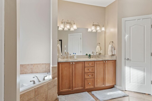 bathroom featuring double vanity, tile patterned flooring, a sink, and a bath