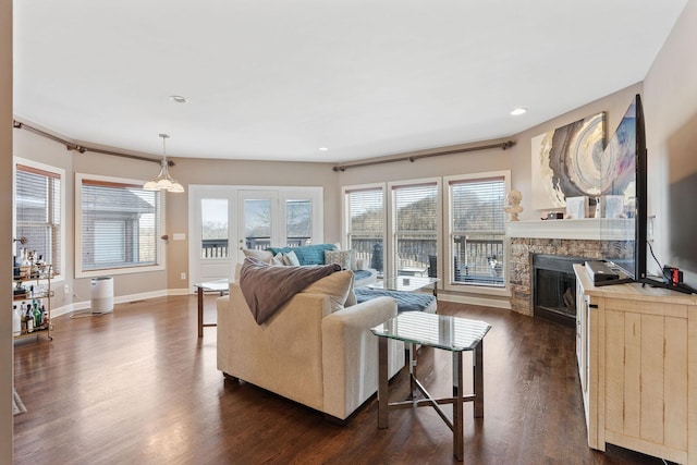 living area featuring recessed lighting, dark wood-style flooring, a fireplace, and baseboards