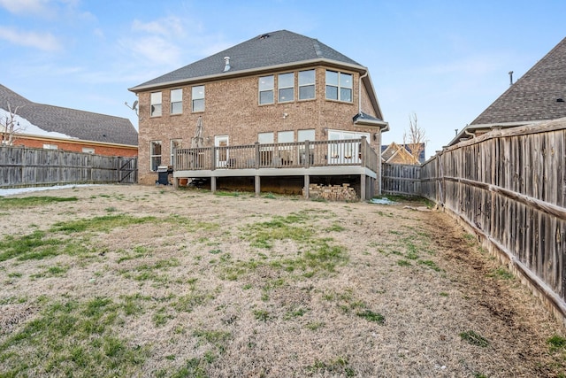 rear view of property with a fenced backyard, brick siding, and a deck