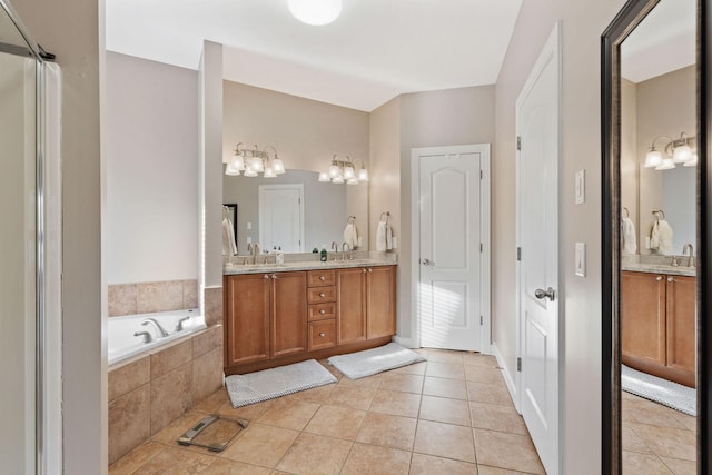 full bath with double vanity, a sink, a bath, and tile patterned floors