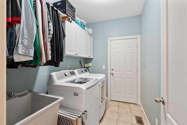 washroom featuring cabinet space, visible vents, baseboards, washing machine and dryer, and a sink